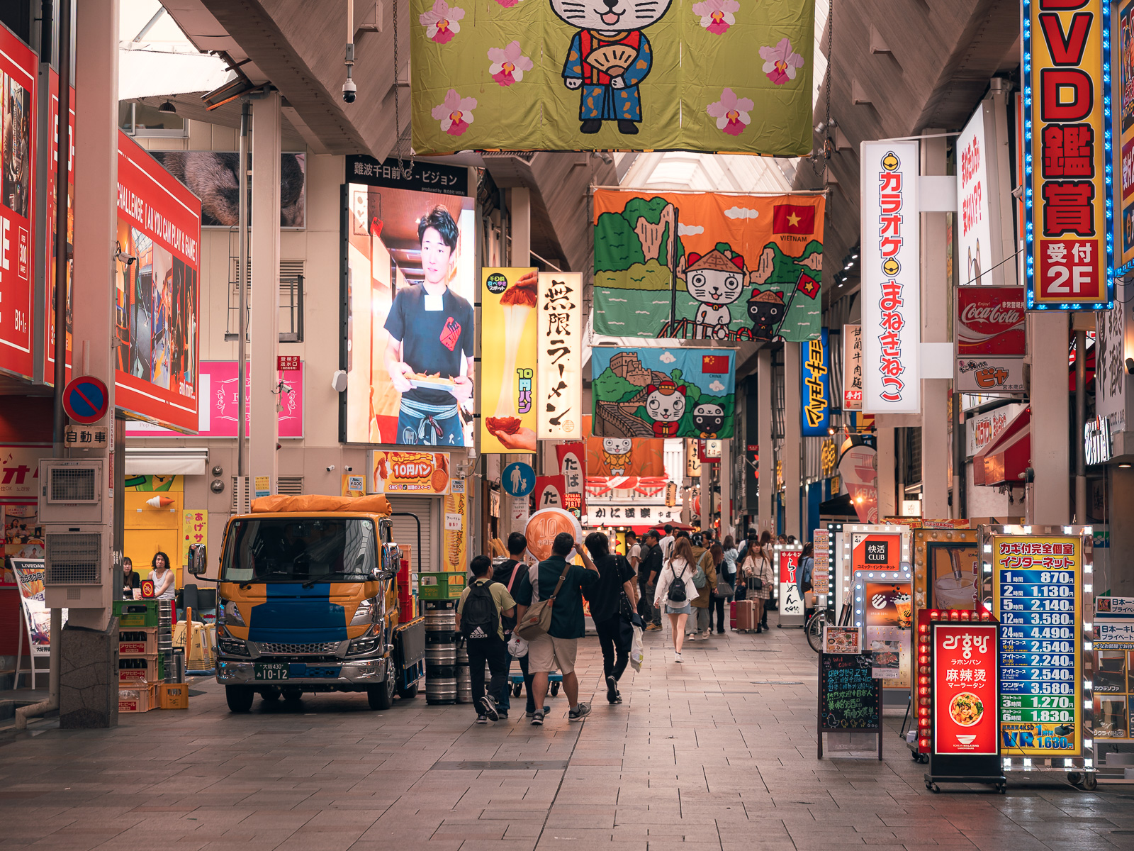 Calle techada con comercios y movimiento urbano en Osaka.