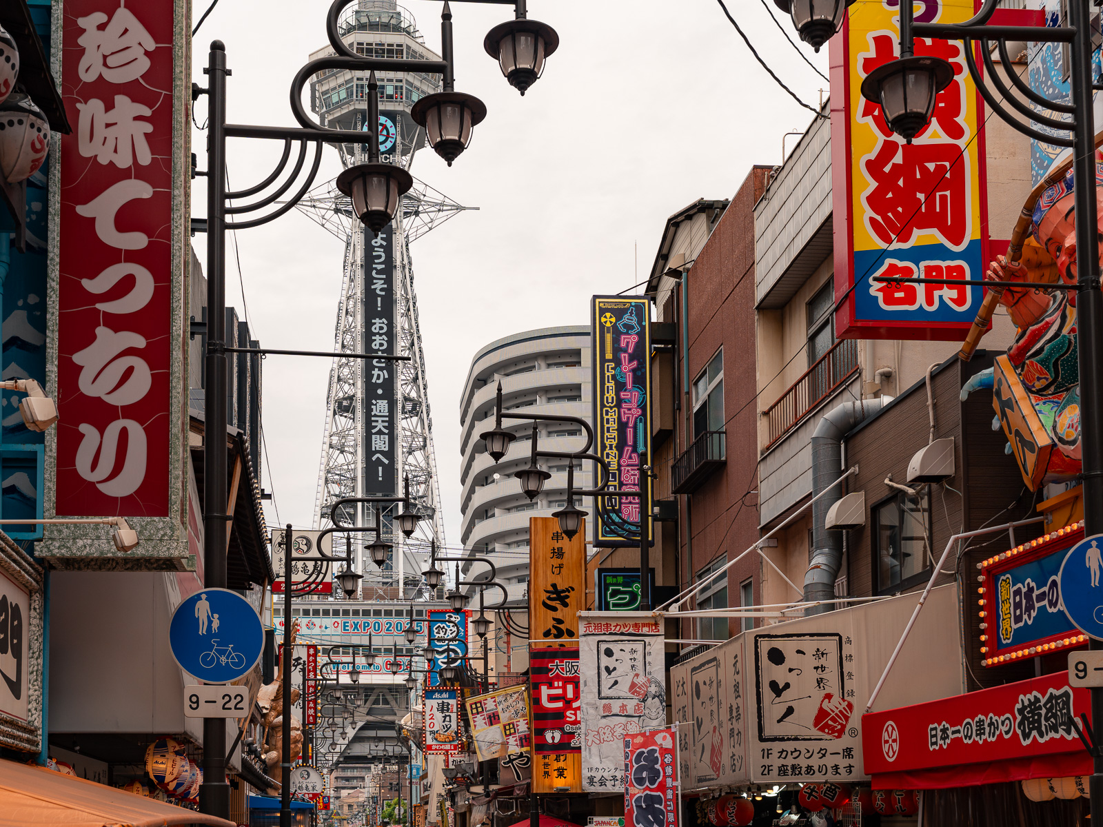 Calles con la torre Tsutenkaku de fondo, en Osaka.