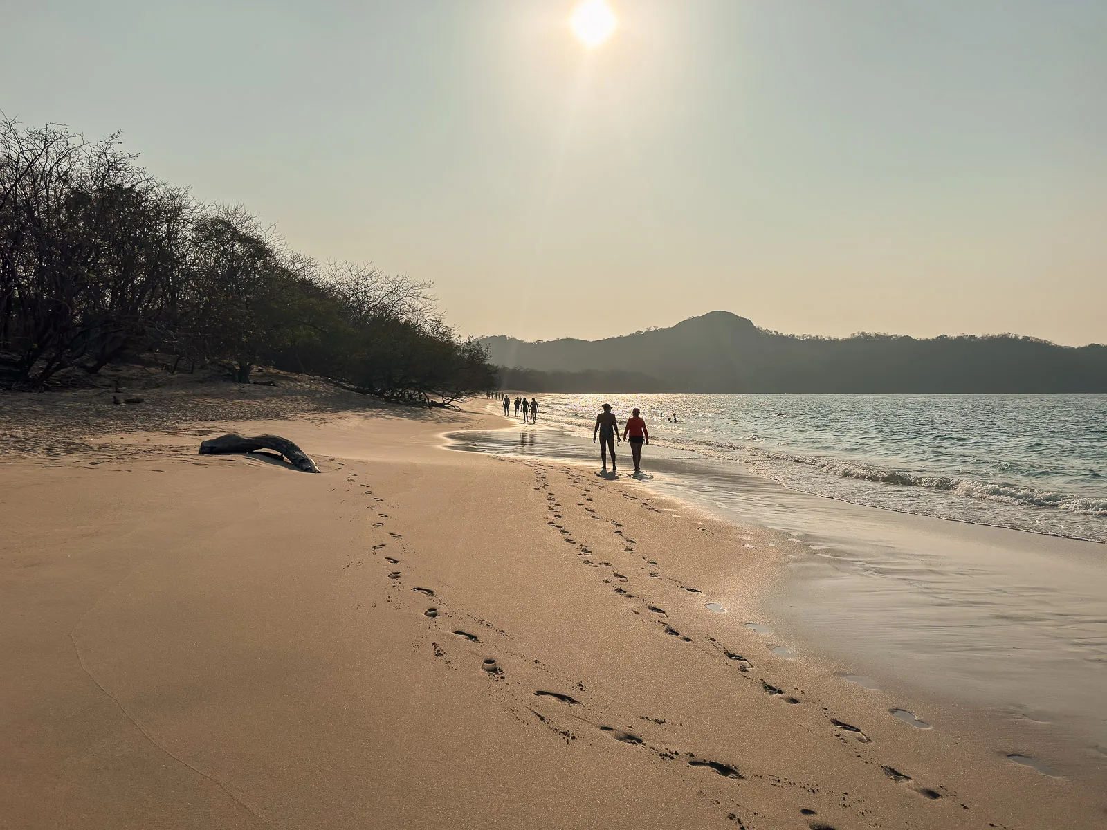 Personas caminando por Playa Conchal al atardecer, Guanacaste
